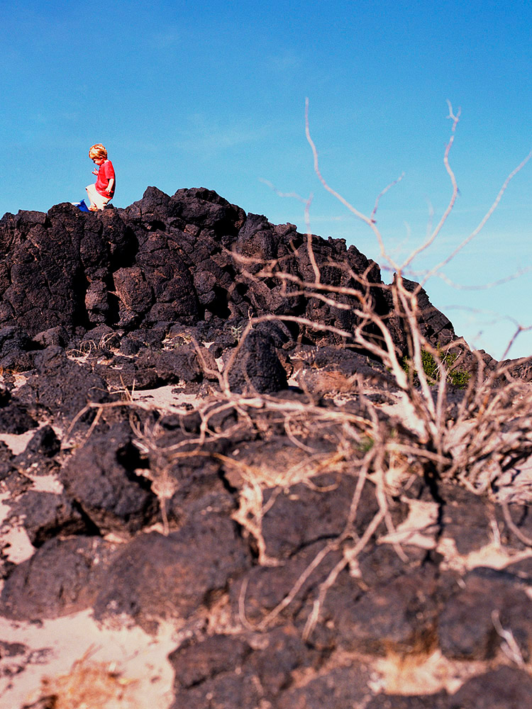 image of toddler kicking blue bucket in lava flow