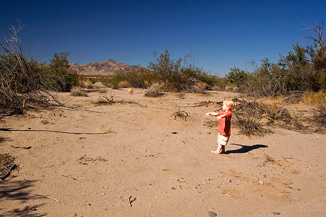 toddler throwing a wax skull in the middle of the desert